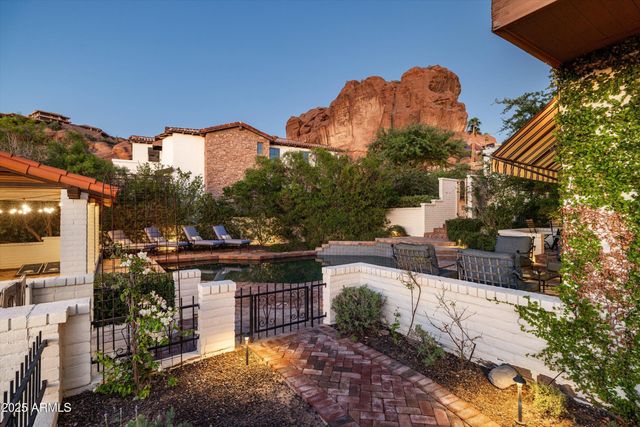 a view of a patio with couches table and chairs under an umbrella with a fire pit