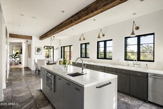 a large white kitchen with a sink and cabinets