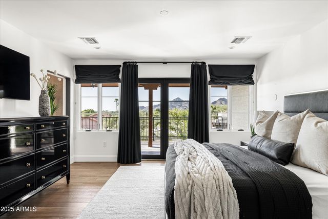 a bedroom with a large bed and a flat tv screen on dresser