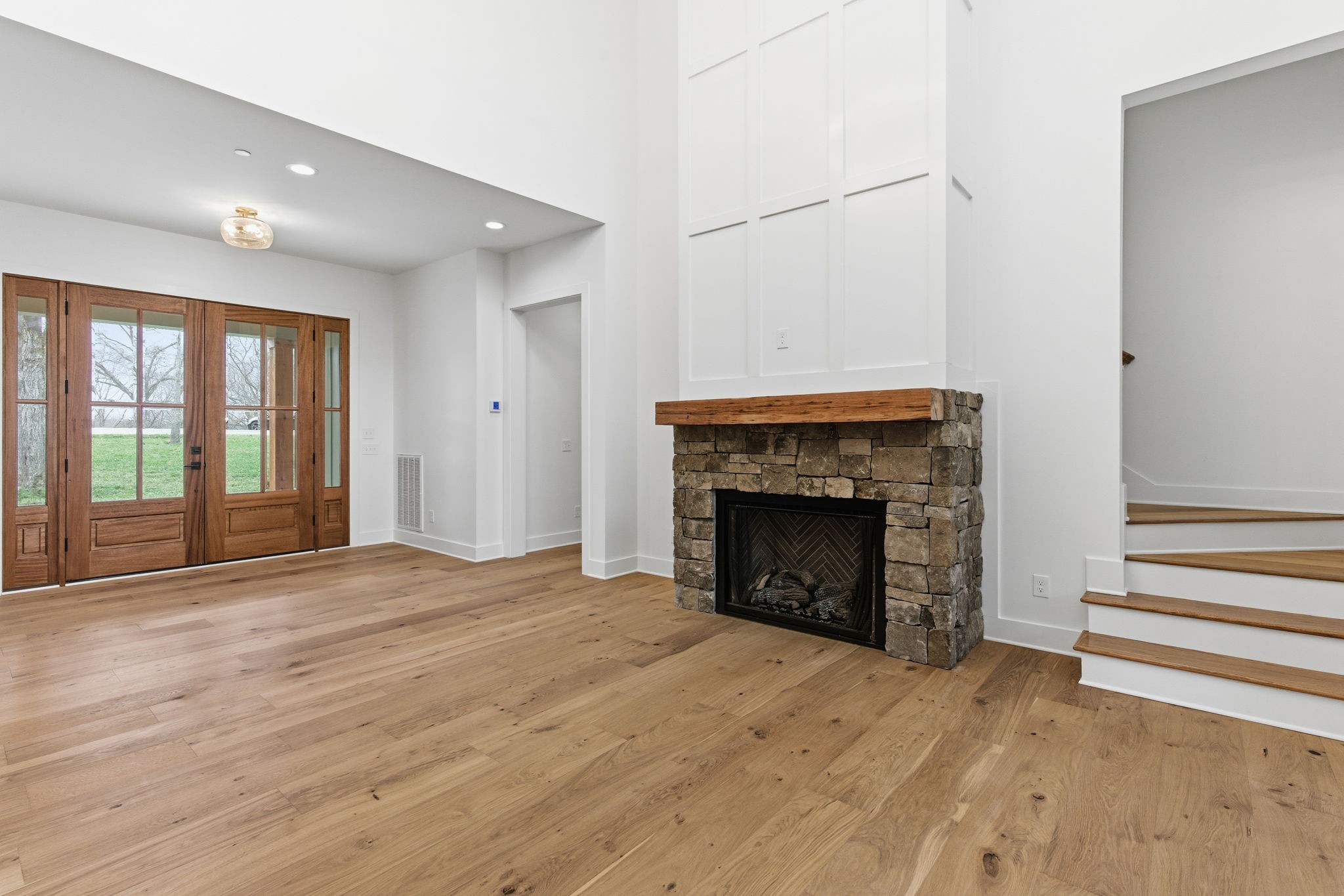 478 Mt Pleasant Road Kingston Springs, TN 37082 - Photo 11 of 59 a view of an empty room with wooden floor fireplace and a window
