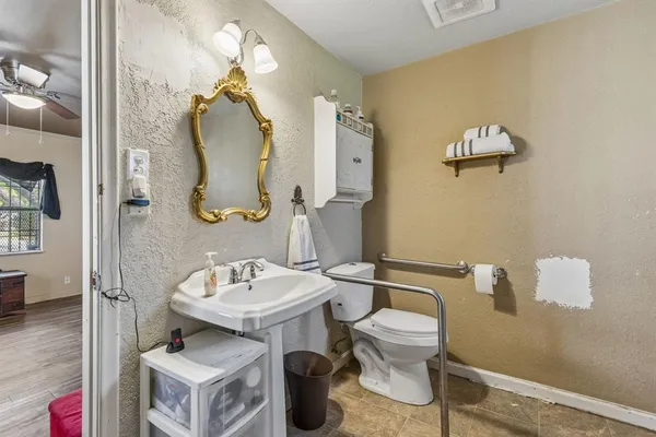 a bathroom with a toilet sink and mirror