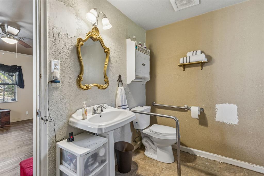 2622 Centerville Road Dallas, TX 75228 - Photo 12 of 22 a bathroom with a toilet sink and mirror