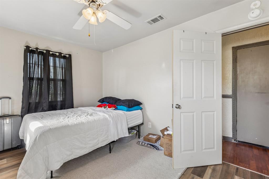 2622 Centerville Road Dallas, TX 75228 - Photo 15 of 22 a bedroom with a bed and a chandelier
