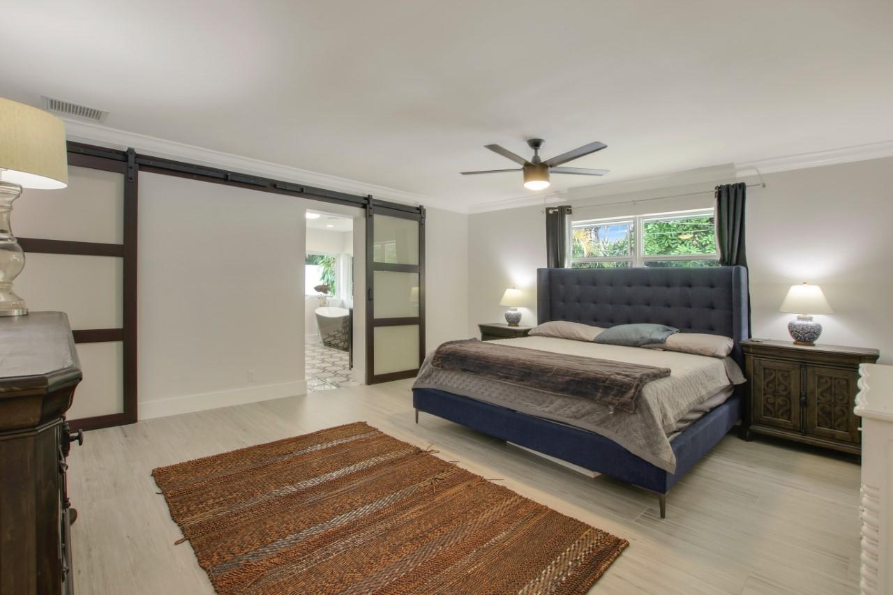 1150 Singer Drive Riviera Beach, FL 33404 - Photo 11 of 20 a bedroom with a large bed and a ceiling fan