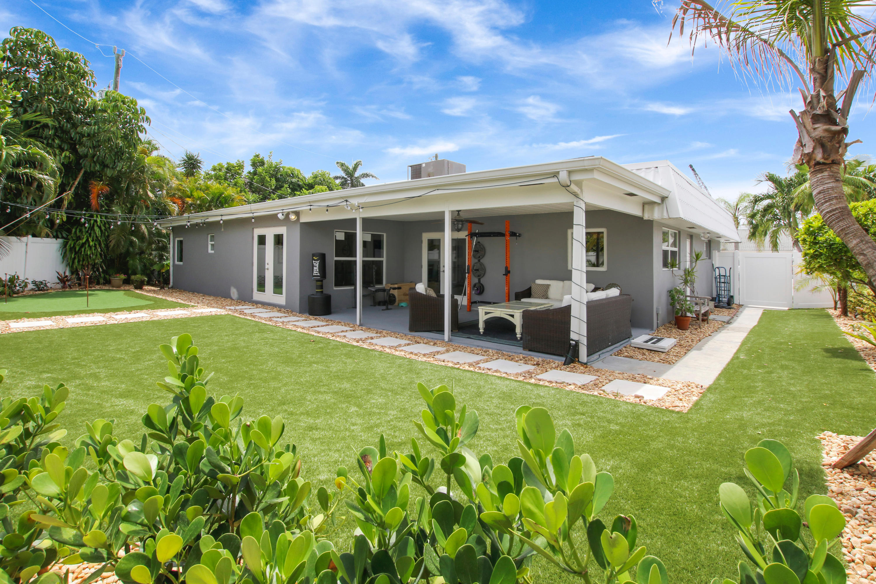 1150 Singer Drive Riviera Beach, FL 33404 - Photo 20 of 20 a view of a house with patio and a garden