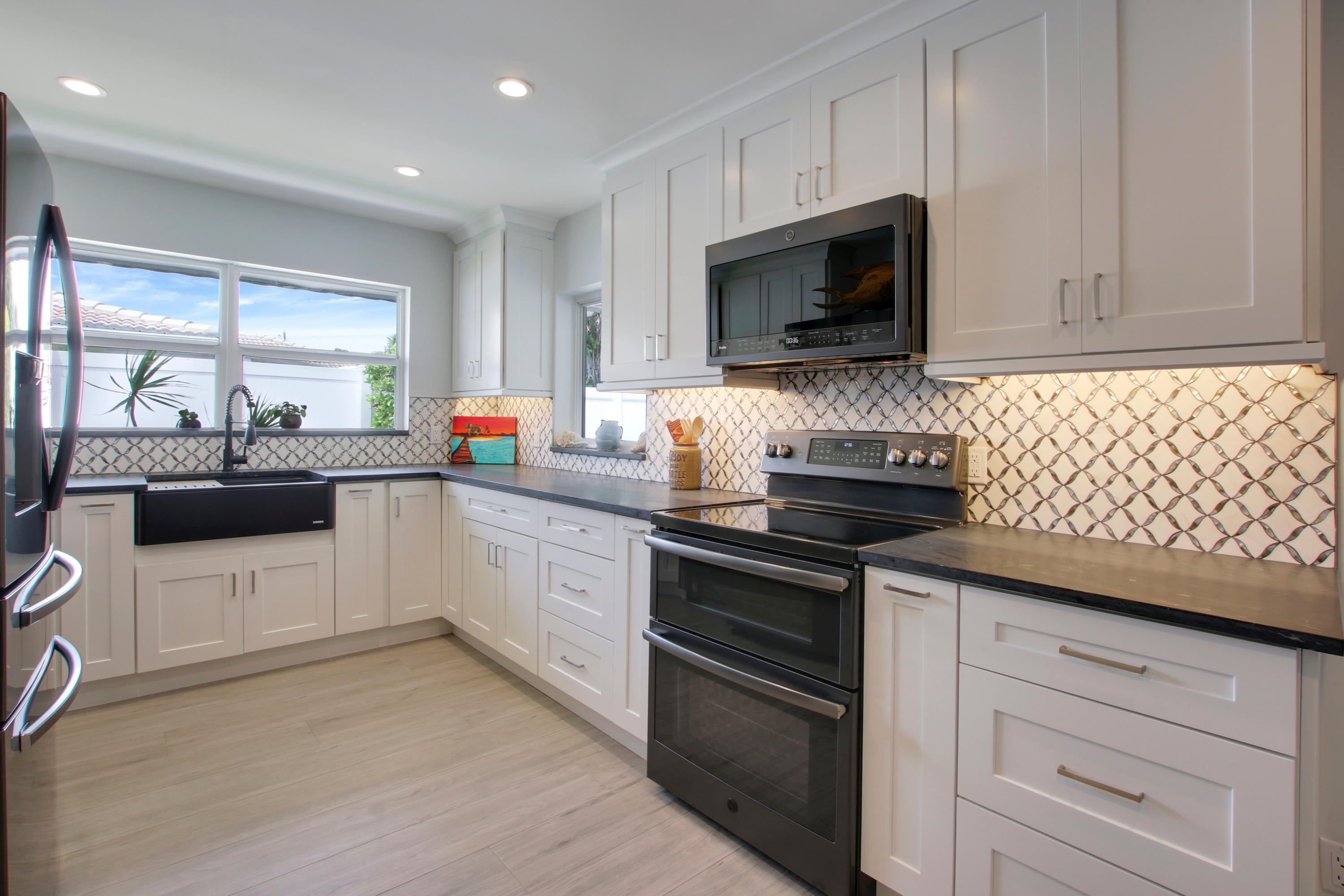 1150 Singer Drive Riviera Beach, FL 33404 - Photo 8 of 20 a kitchen with stainless steel appliances a stove microwave and sink