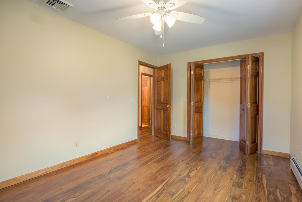 2 Wintergreen Circle Amherst, MA 01002 - Photo 20 of 37 an empty room with wooden floor and a ceiling fan