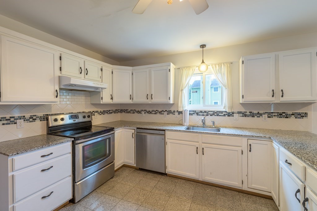 2 Wintergreen Circle Amherst, MA 01002 - Photo 3 of 37 a kitchen with granite countertop white cabinets white stainless steel appliances and a sink