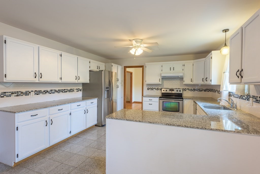 2 Wintergreen Circle Amherst, MA 01002 - Photo 6 of 37 a kitchen with granite countertop a stove a sink a refrigerator and cabinets