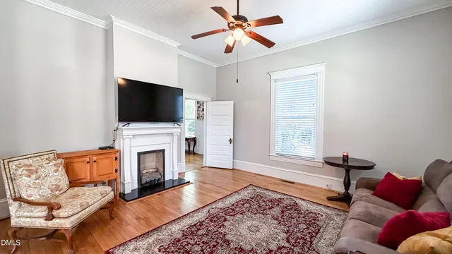 a dining room with wooden floor a chandelier a wooden table and chairs
