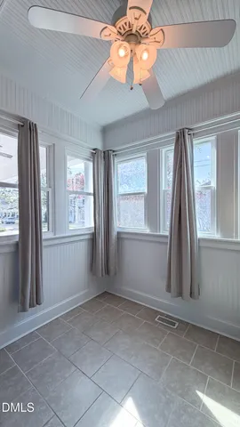 a bedroom with a bed and a flat tv screen on dresser