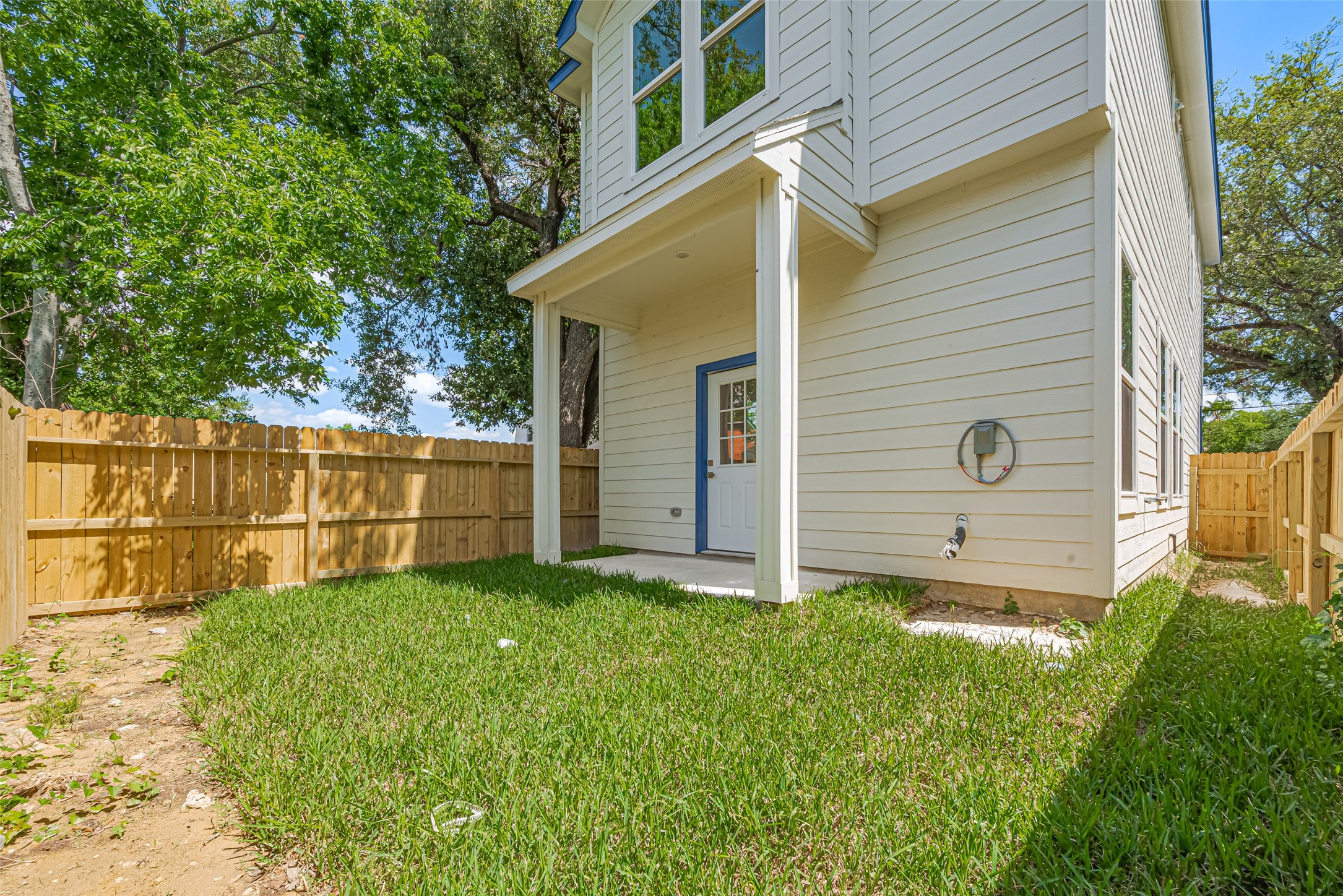 7207 Force Street Houston, TX 77020 - Photo 27 of 29 A small, fenced backyard with a grassy area and a covered entrance.