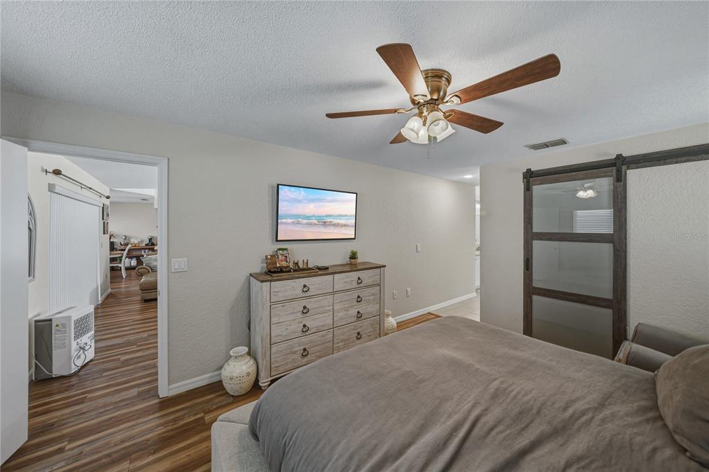 7435 Kilbride Court Weeki Wachee, FL 34613 - Photo 36 of 67 a bedroom with a bed and a chandelier