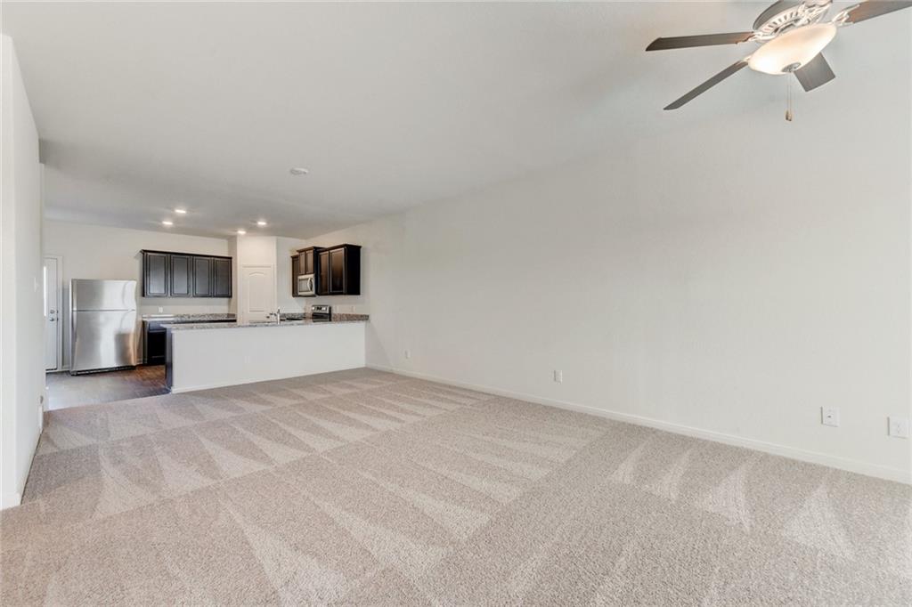 105 Brunswick Lane Jarrell, TX 76537 - Photo 16 of 16 Unfurnished living room featuring light carpet, a ceiling fan, and recessed lighting