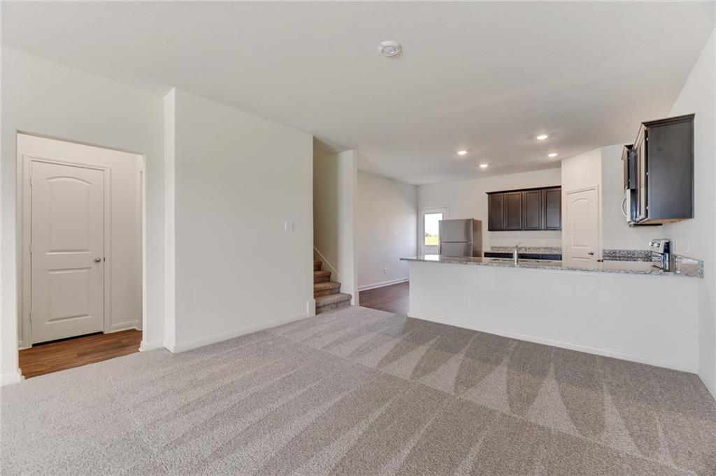 105 Brunswick Lane Jarrell, TX 76537 - Photo 5 of 16 Unfurnished living room featuring dark carpet and recessed lighting