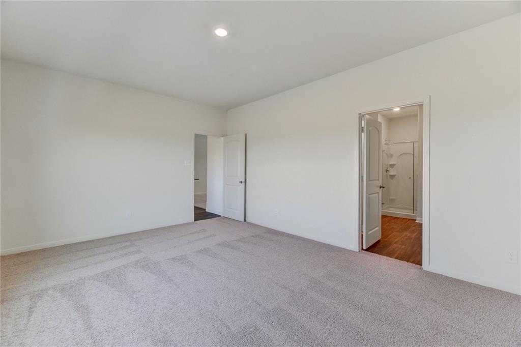 105 Brunswick Lane Jarrell, TX 76537 - Photo 9 of 16 Unfurnished bedroom featuring light colored carpet, recessed lighting, and ensuite bath