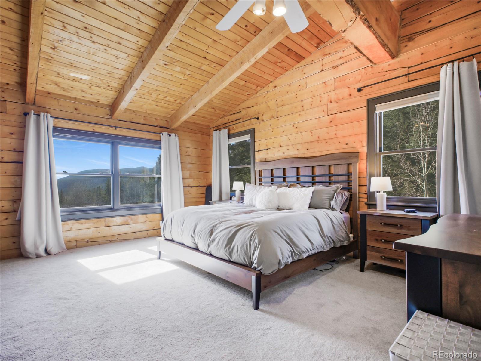 24 Pine Valley Road Evergreen, CO 80439 - Photo 15 of 50 a spacious bedroom with a bed and large window with balcony view