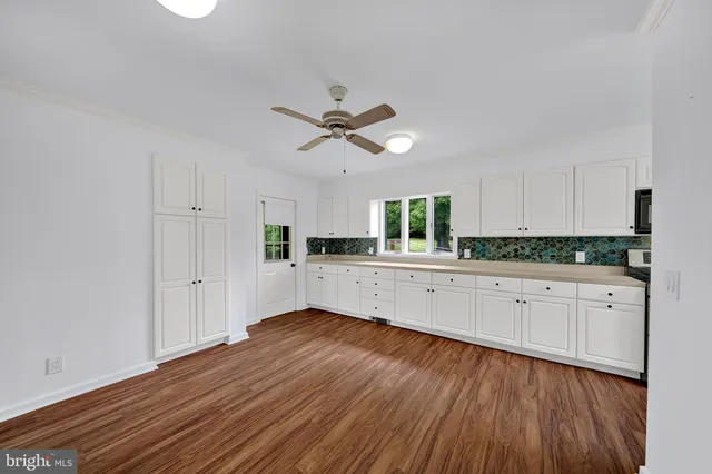 a view of a kitchen with wooden floor and electronic appliances