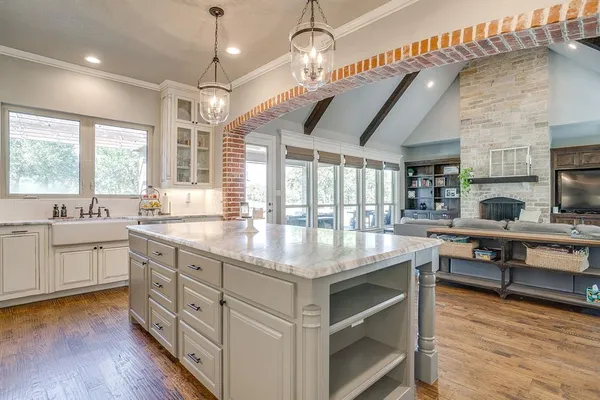 a kitchen with kitchen island granite countertop a stove and a wooden floors