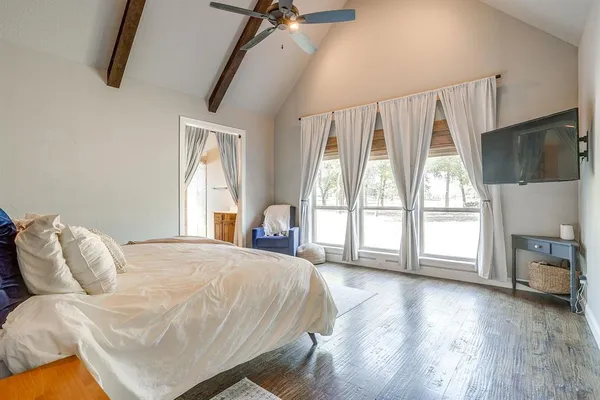 a bedroom with a bed and a flat tv screen on the dresser