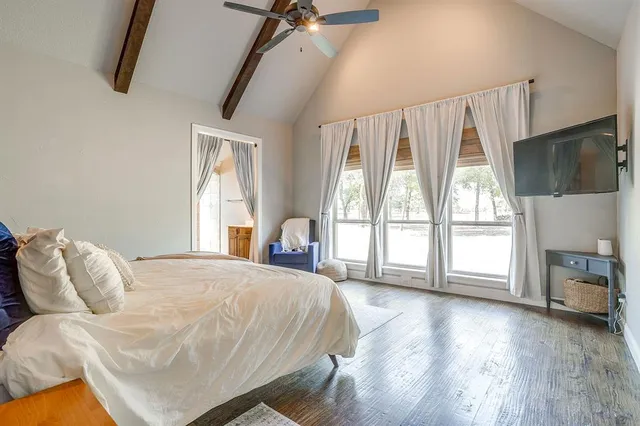 a bedroom with a bed and a flat tv screen on the dresser