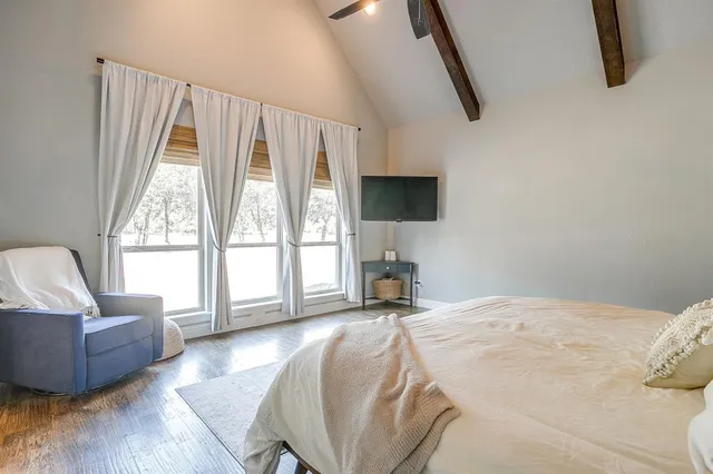 a spacious bedroom with a bed and glass window