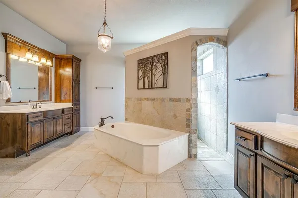 a spacious bathroom with a tub sink and mirror