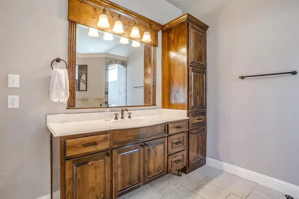 a bathroom with a granite countertop sink and a mirror