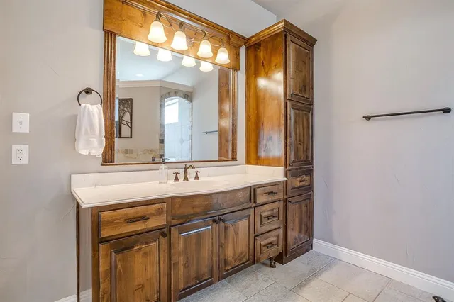 a bathroom with a granite countertop sink and a mirror