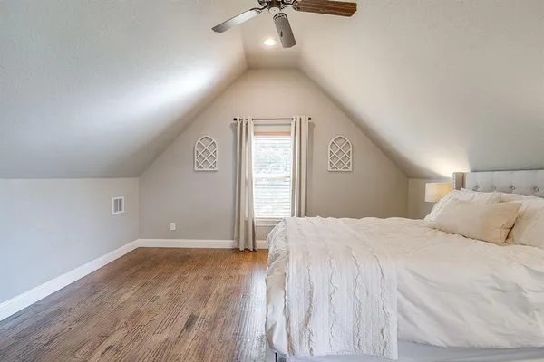 a bedroom with a large bed and a chandelier