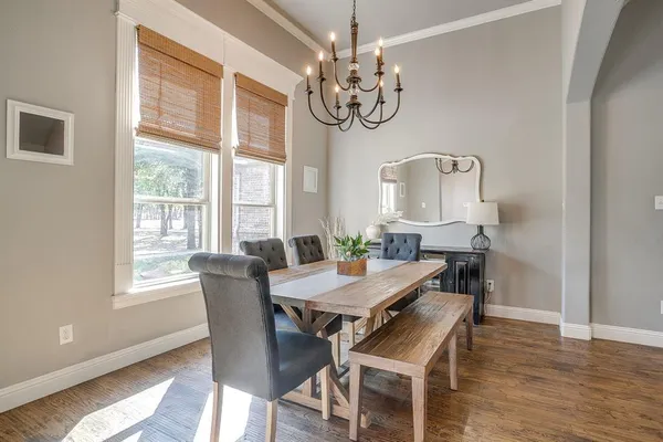 a view of a dining room with furniture a chandelier and wooden floor