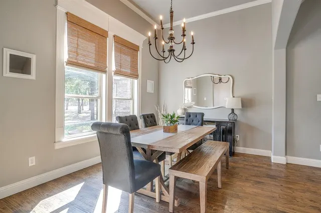 a view of a dining room with furniture a chandelier and wooden floor
