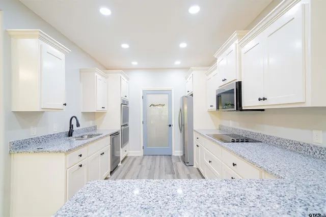 a large kitchen with stainless steel appliances granite countertop a stove a sink and a granite counter tops