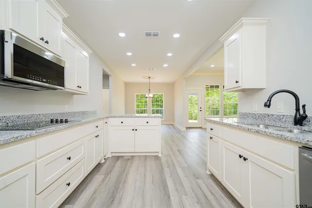a large white kitchen with a large window