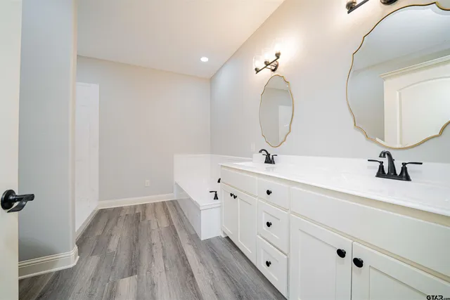 a bathroom with a sink mirror and vanity