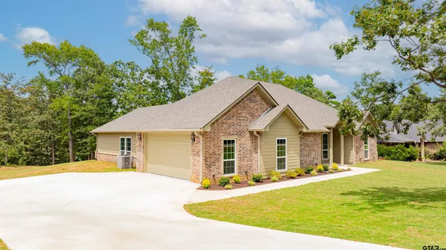 a front view of house with yard and trees around