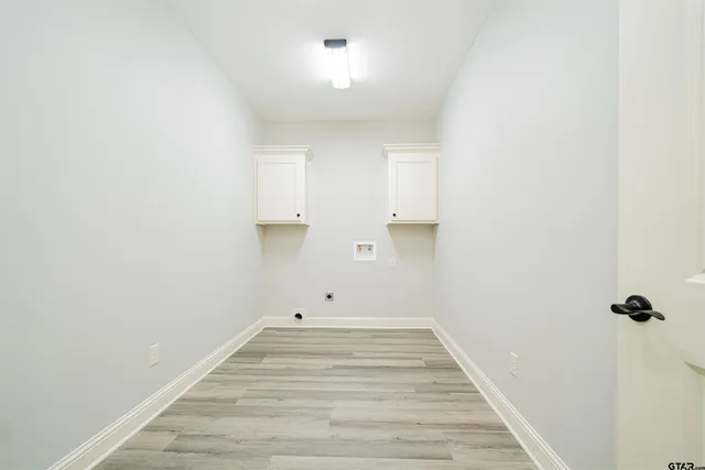 an empty room with wooden floor and ceiling fan