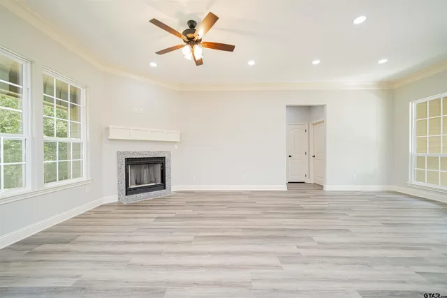 a view of empty room with wooden floor and fireplace