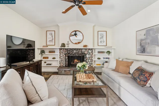 a living room with furniture a flat screen tv and a fireplace