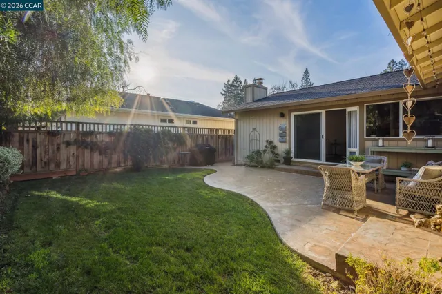 a view of a house with backyard and sitting area