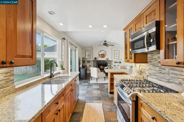 a kitchen with stainless steel appliances granite countertop a stove a sink and a microwave