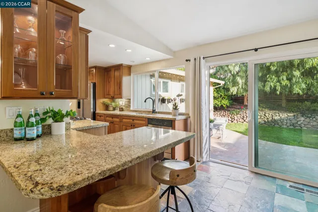 a kitchen with granite countertop sink and glass top table
