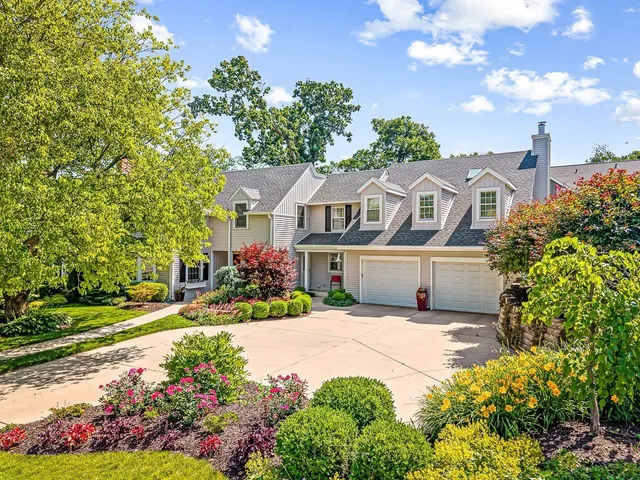 a front view of a house with a yard and a garden