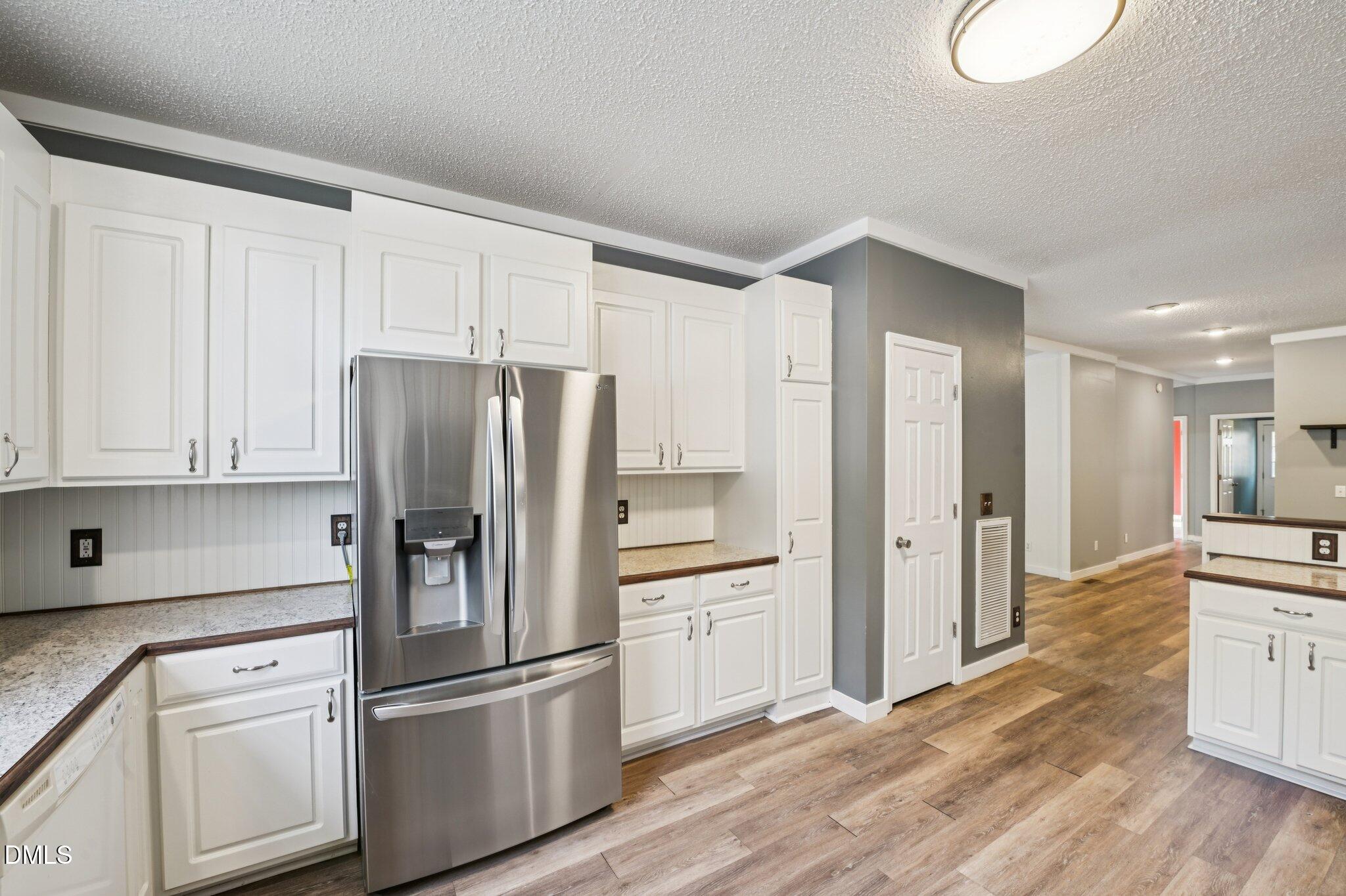 5393 Frazier Road Spring Hope, NC 27882 - Photo 11 of 23 a kitchen with stainless steel appliances granite countertop a refrigerator sink and white cabinets
