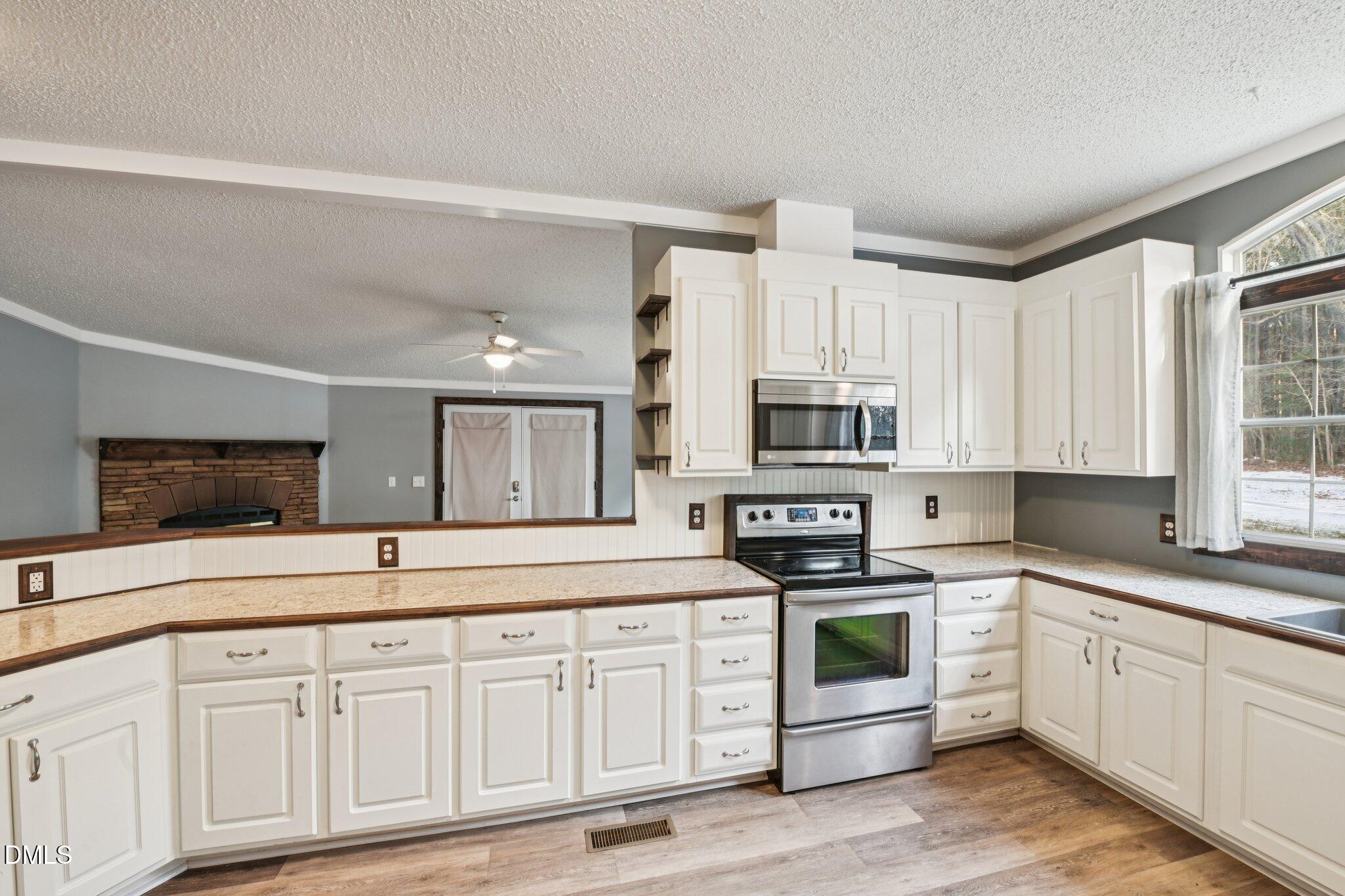 5393 Frazier Road Spring Hope, NC 27882 - Photo 7 of 23 a kitchen with granite countertop white cabinets and white appliances