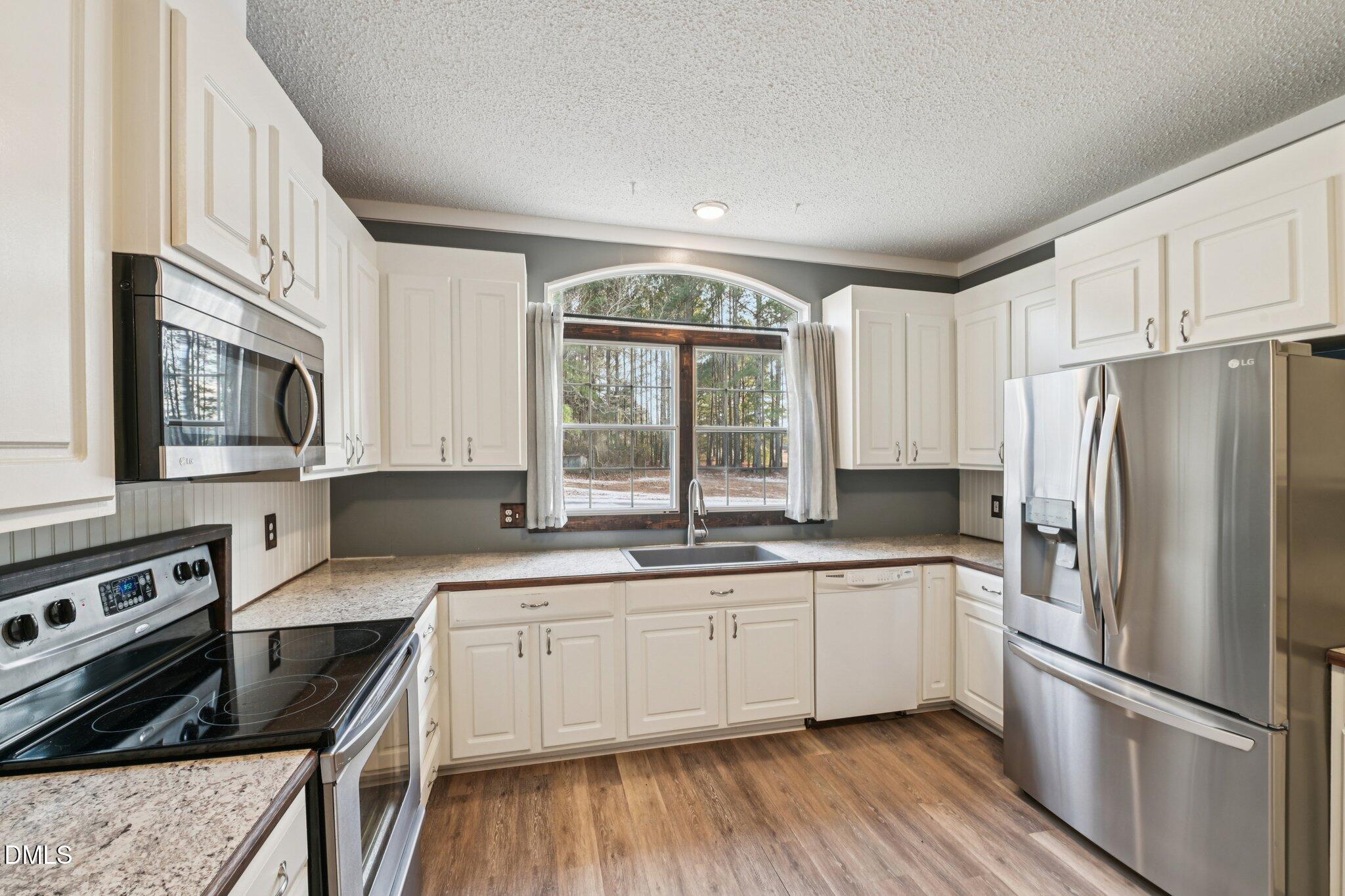 5393 Frazier Road Spring Hope, NC 27882 - Photo 8 of 23 a kitchen with a sink a window a counter and stainless steel appliances