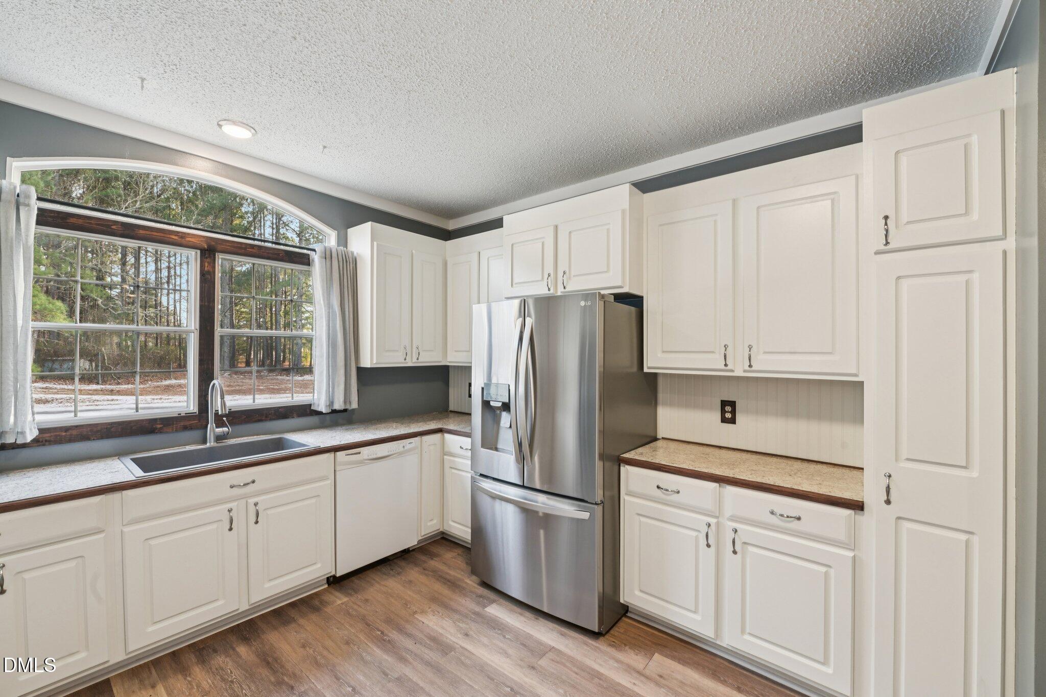 5393 Frazier Road Spring Hope, NC 27882 - Photo 9 of 23 a kitchen with white cabinets white stainless steel appliances and sink