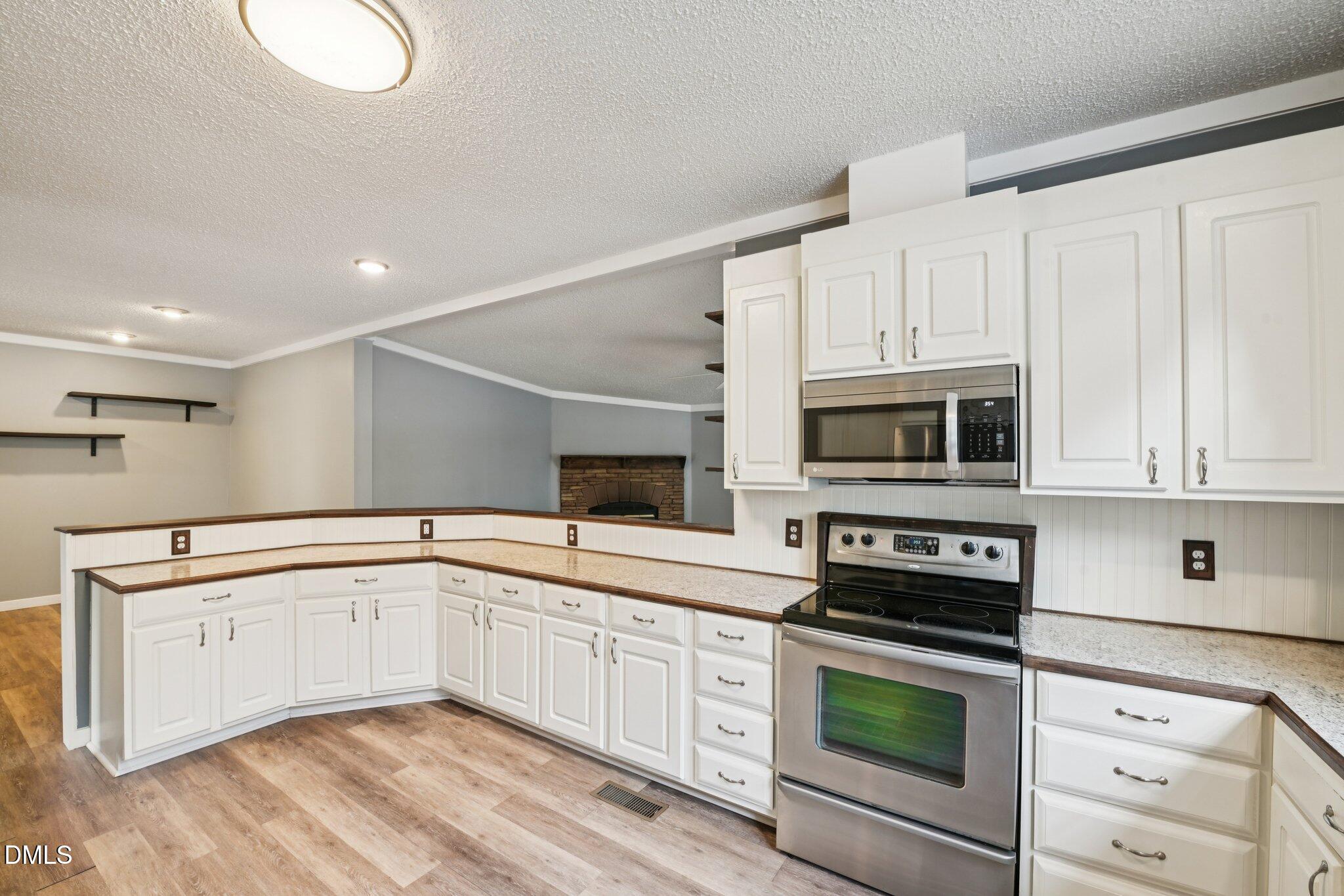 5393 Frazier Road Spring Hope, NC 27882 - Photo 10 of 23 a kitchen with granite countertop a sink stainless steel appliances and white cabinets