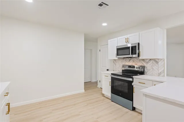 a kitchen with a sink a stove top oven and white stainless steel appliances
