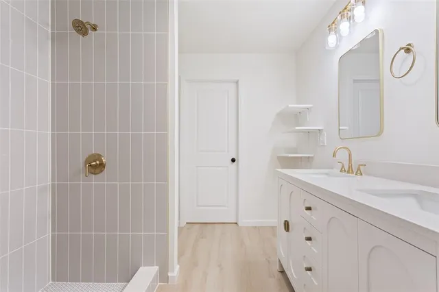 a bathroom with a sink vanity granite tub shower and a mirror